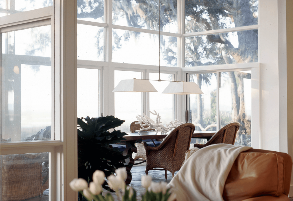 living area with Glass walls overlooking backyard with marsh